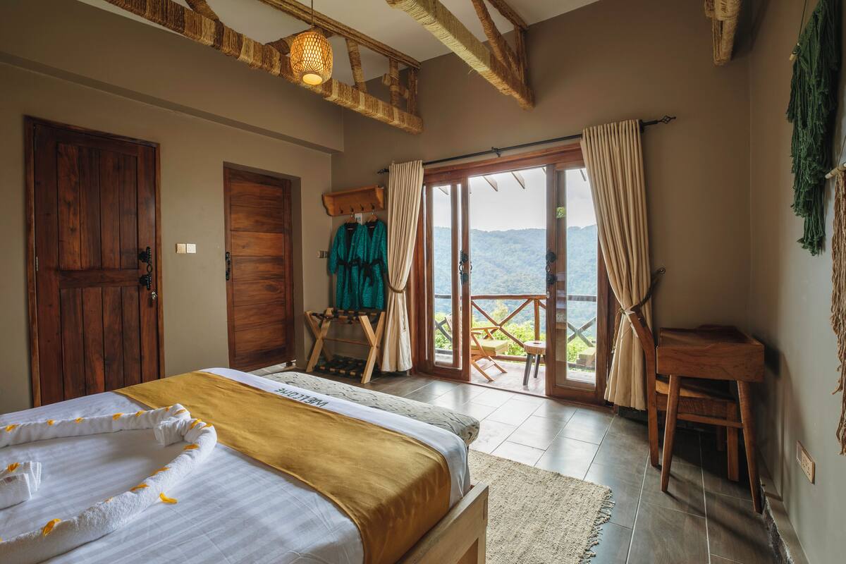 Un dormitorio con cama, armario de madera y balcón con vistas.
