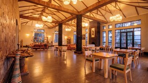 A spacious interior with high ceilings, wooden beams, and large windows. - Kaara Gorilla Mountain Lodge (Bugambira)
