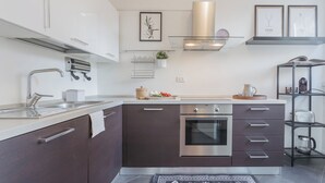 A modern kitchen with stainless steel appliances, a built-in oven, and a coffee machine. - Chiara's Apartment by Rent all Como (Como)