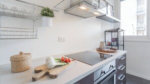 A modern kitchen with a large island, built-in shelves, and a window with a city view. - Chiara's Apartment by Rent all Como (Como)