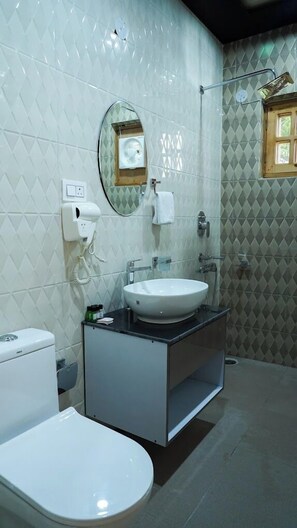 Une salle de bain équipée de toilettes, d’un lavabo et d’une douche.