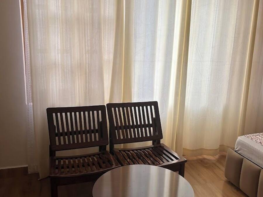 Una habitación con un banco de madera, una mesa redonda y una cama.