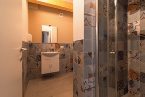 Quarto casal luxo | Banheiro | Chuveiro, toalhas de banho, shampoo, papel higiênico