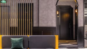 A modern lobby with a seating area, a reception desk, and an elevator. - A forest s hotel (Shanghai)