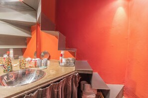 A bathroom with a sink, mirror, and various toiletries. - La Corte Degli Artisti by Rent all Como (Blevio)