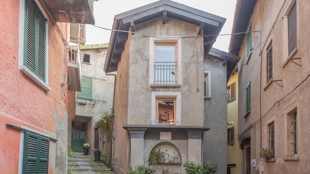 A narrow alleyway with a building featuring a small balcony and a door leading to a staircase. - La Corte Degli Artisti by Rent all Como (Blevio)