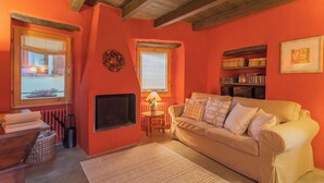 A cozy living room with a beige sofa, a fireplace, a bookshelf, and a window with a view. - La Corte Degli Artisti by Rent all Como (Blevio)