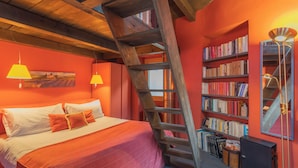 A bedroom with a wooden ladder, a bookshelf, and a bed with a red bedspread. - La Corte Degli Artisti by Rent all Como (Blevio)