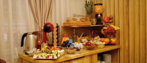 A breakfast buffet with various fruits, pastries, and beverages.