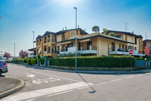 A multi-story residential building with balconies, a stop sign, and a clear sky.