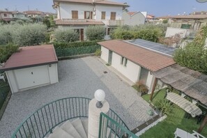 A residential area with a house featuring a solar panel, a covered patio, and a staircase leading to an upper floor. - Villa Natalina - Two-Bedroom Apartment with Air Conditioning and Wi-Fi (Sirmione)