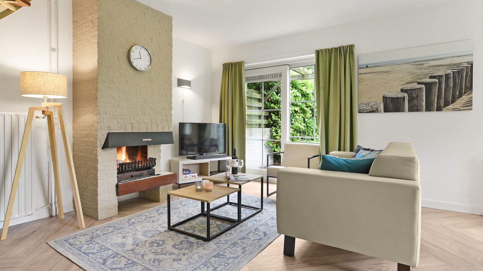Ein Wohnzimmer mit Kamin, Fernseher, Sofa und Couchtisch.