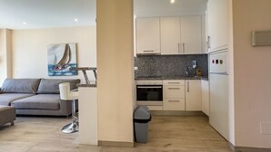 A modern kitchen with white cabinets, a granite countertop, and a built-in oven.