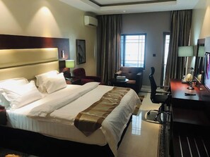 Relax in comfort with a large bed, desk, and flat-screen TV.