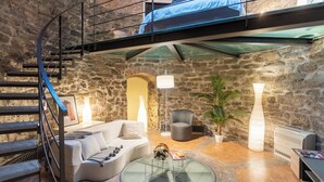 A cozy interior with a spiral staircase, a sofa set, a glass coffee table, and a bed in a loft area. - Ice Queen Chamber by Rent all Como (Como)