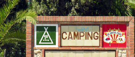 Placa de Vilanova Park com símbolos de camping e um logotipo.