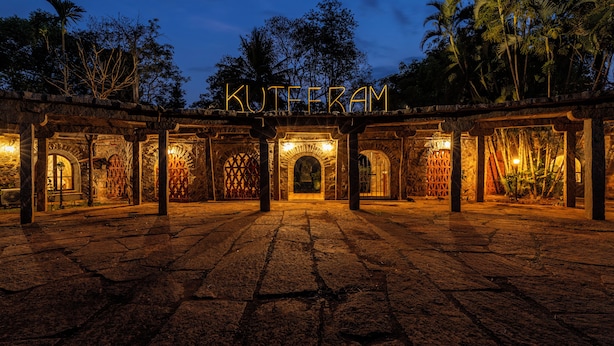 A stone courtyard with arches and a sign reading "KUTEFRAM". - Amã Stays & Trails Kuteeram, Bangalore (Doddaballapur)