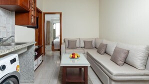 A compact living space with a kitchenette, a sofa, and a small table with fruit. - Lazur Sea & City Apartment's - El Hadaba, Hurghada - Egypt (Hurghada)