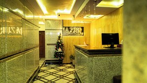 A hotel lobby with a reception desk, a Christmas tree, and a sign that reads "AZUR". - Lazur Sea & City Apartment's - El Hadaba, Hurghada - Egypt (Hurghada)