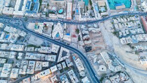 An aerial view of a coastal city with a marina, residential buildings, and a road network. - Lazur Sea & City Apartment's - El Hadaba, Hurghada - Egypt (Hurghada)