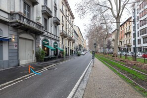 A street with buildings, a sidewalk, and a tram line. - notaMi - UP&DOWN Monte Nero (Milan)
