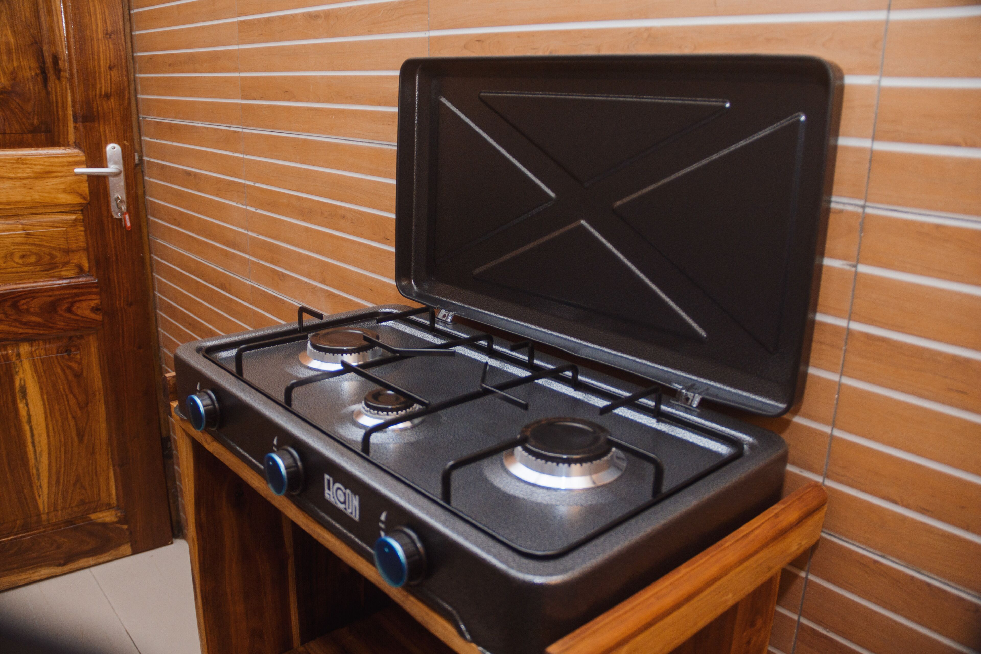 A kitchen with a gas stove, wooden cabinets, and a tiled backsplash.