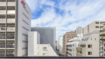 Vista de un paisaje urbano con edificios modernos, incluyendo un edificio blanco destacado con un logotipo rojo a la izquierda.