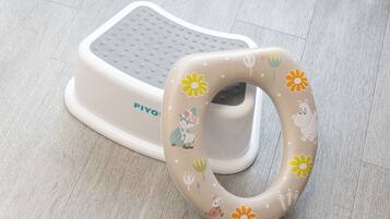 Un porteur pour bébé doté d’un motif floral et d’une plateforme pour les pieds.