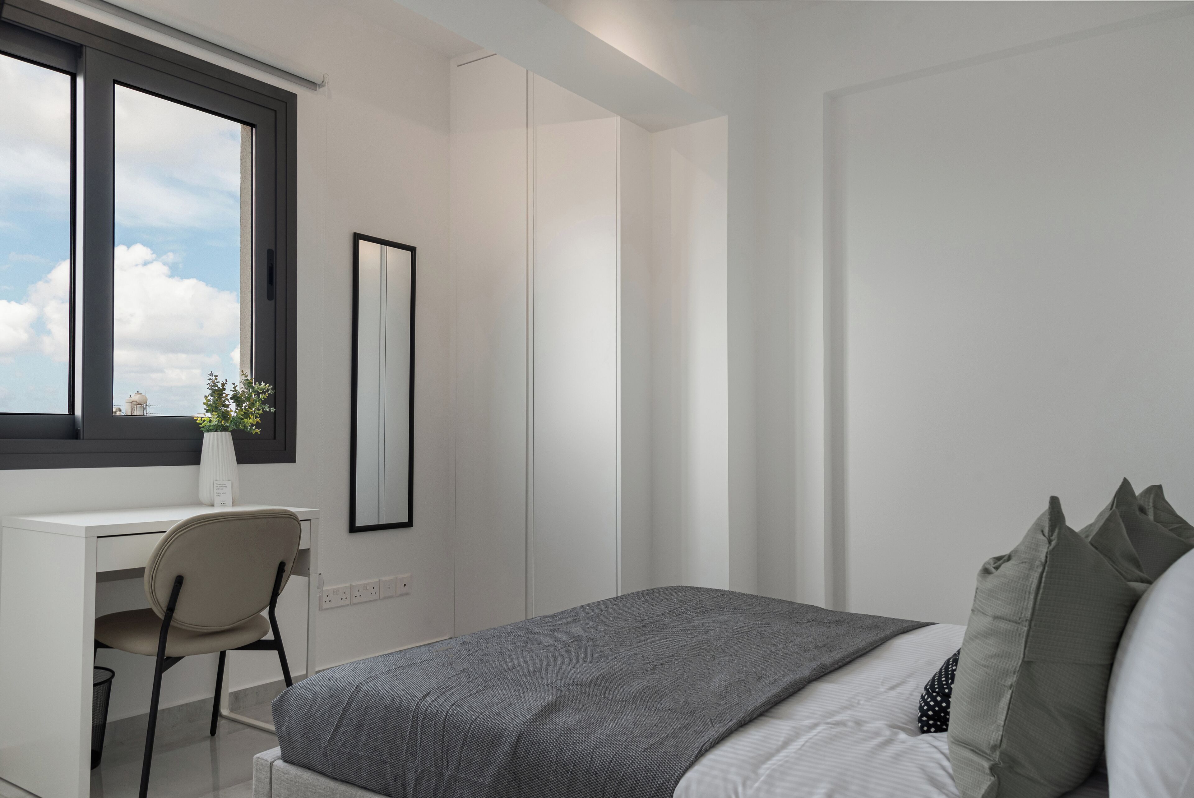 Ein modernes Schlafzimmer mit einem Bett, einem Schreibtisch und einem Stuhl.
