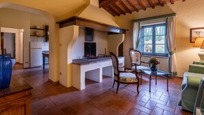 Una cocina acogedora con techo de madera, un comedor con una silla y una mesa, y vista al exterior a través de una ventana.