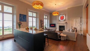 A spacious living area with a large island, a fireplace, and a television displaying 'NETFLIX'. - Historic Seaview Gem in Ramsgate by Adliv (RAMSGATE)