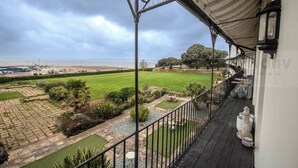 A balcony with a view of a landscaped garden and beach. - Historic Seaview Gem in Ramsgate by Adliv (RAMSGATE)