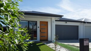 A modern house with a garage, a wooden door, and a mailbox with the number 25. - Modern 3B house, pet friendly close nature reserve (Throsby)