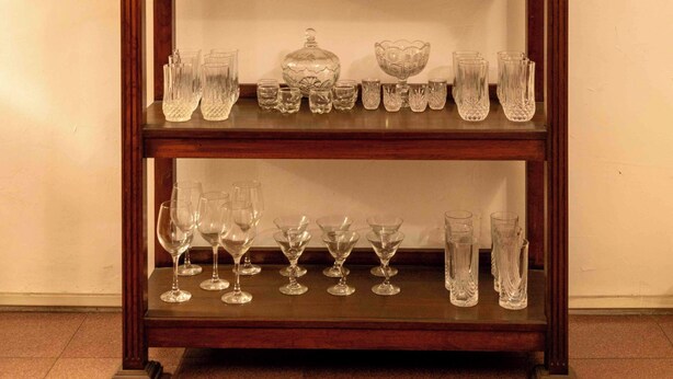 Una estantería de madera con vajillas de porcelana y cristalería.