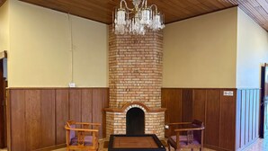 A room with a brick fireplace, wooden paneling, a billiards table, and two chairs. - Cottage 88 (Nuwara Eliya)