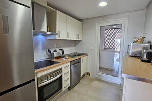 A modern kitchen with stainless steel appliances, white cabinetry, and a built-in oven. - Beautiful apartment PA923LT, Casa Gironi (Murcia)