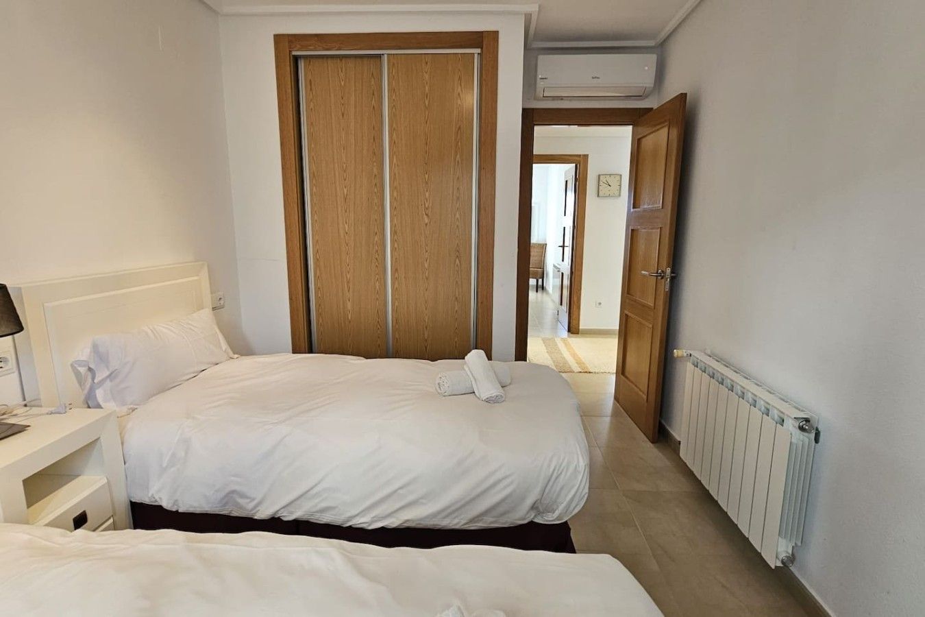 Ein Hotelzimmer mit einem Bett, einem Nachttisch und einem Holzschrank.