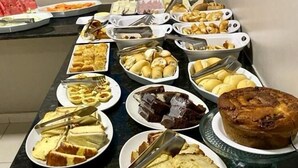 A buffet table with various dishes including cakes, pastries, and desserts. - Pousada Caribe Brasileiro (Maragogi)