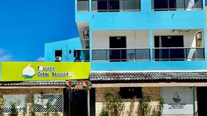 A two-story building with a blue facade, balconies, and a sign for 'Pousada Caribe Brasil'. - Pousada Caribe Brasileiro (Maragogi)