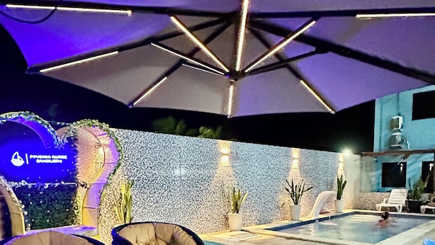 An outdoor pool area with lounge chairs and umbrellas. - Pousada Caribe Brasileiro (Maragogi)