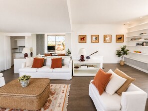A modern living room with a white sofa, a coffee table, and a bookshelf. - Penthouse with Terrace near Pantheon (Roma)