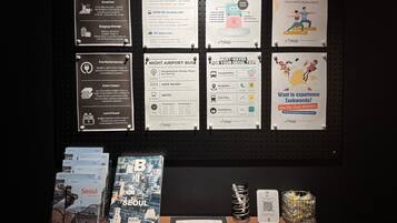 A bulletin board with various travel information and a table with books and a guidebook.