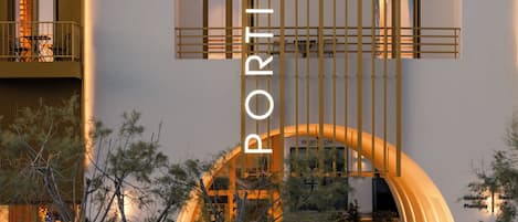 Ein modernes Gebäude mit einem markanten Bogenportal und einer vertikalen Beschilderung mit dem Schriftzug "PORTAN".