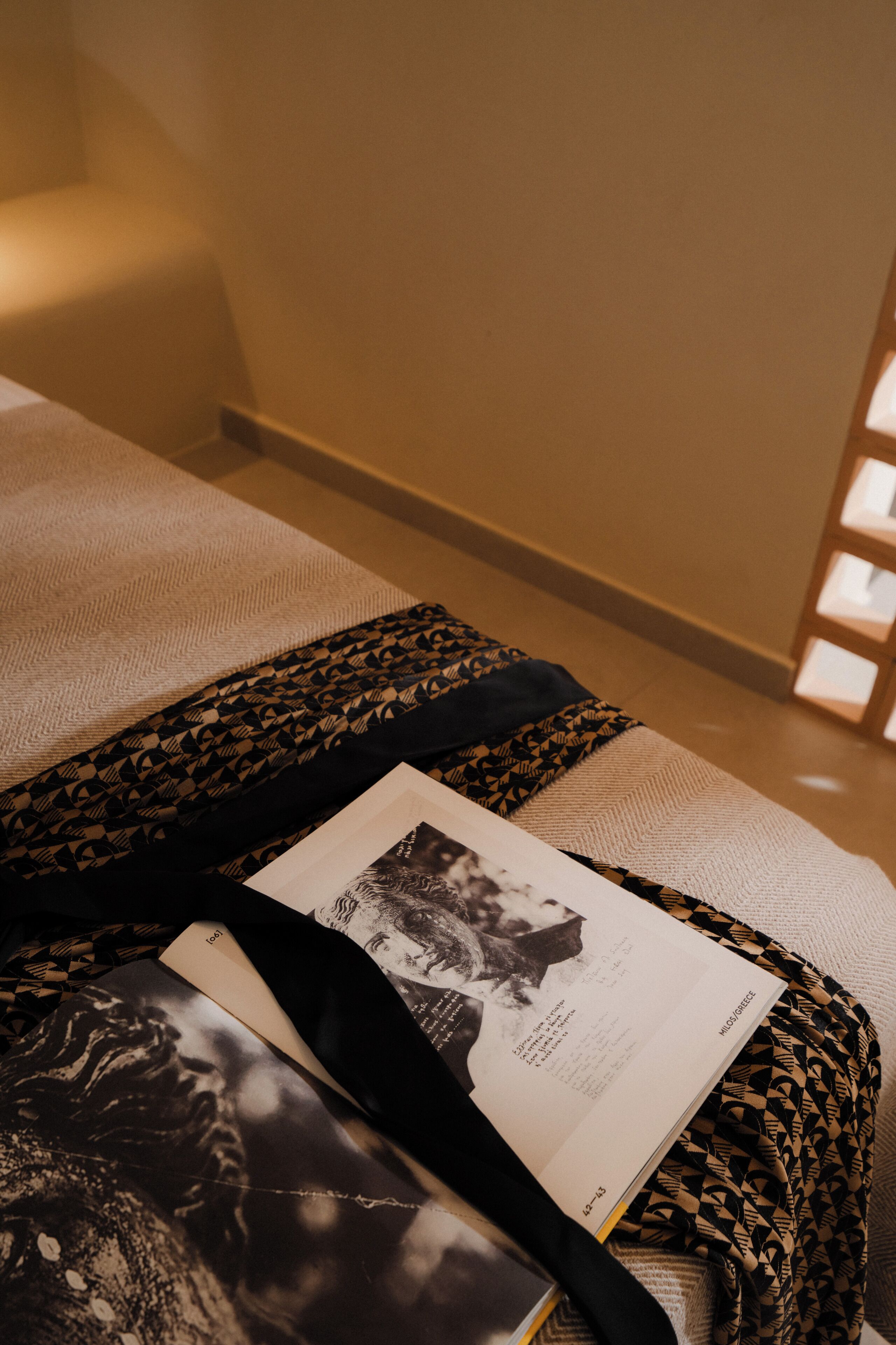 Ein Bett mit einer geblümten Decke, einem Buch und einer Zeitschrift darauf.