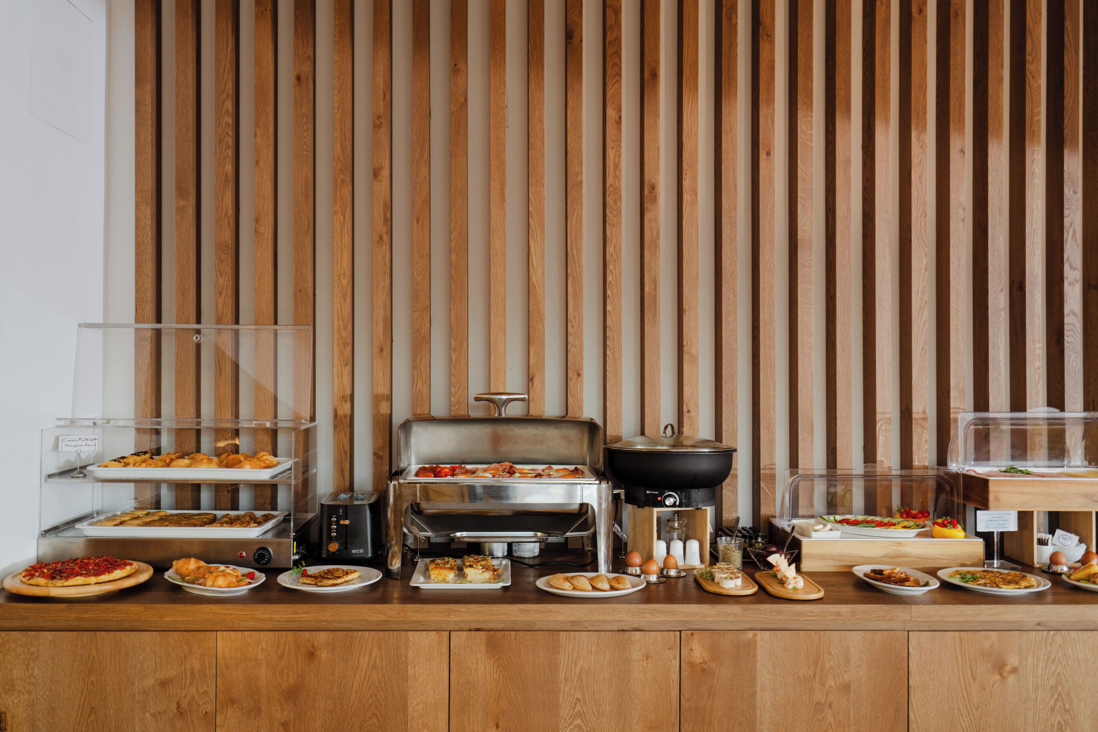 Un buffet proposant une variété de plats, un barbecue et un coin café.