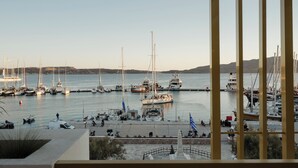 Un port de plaisance où sont amarrés plusieurs voiliers, un petit bateau et quelques yachts.