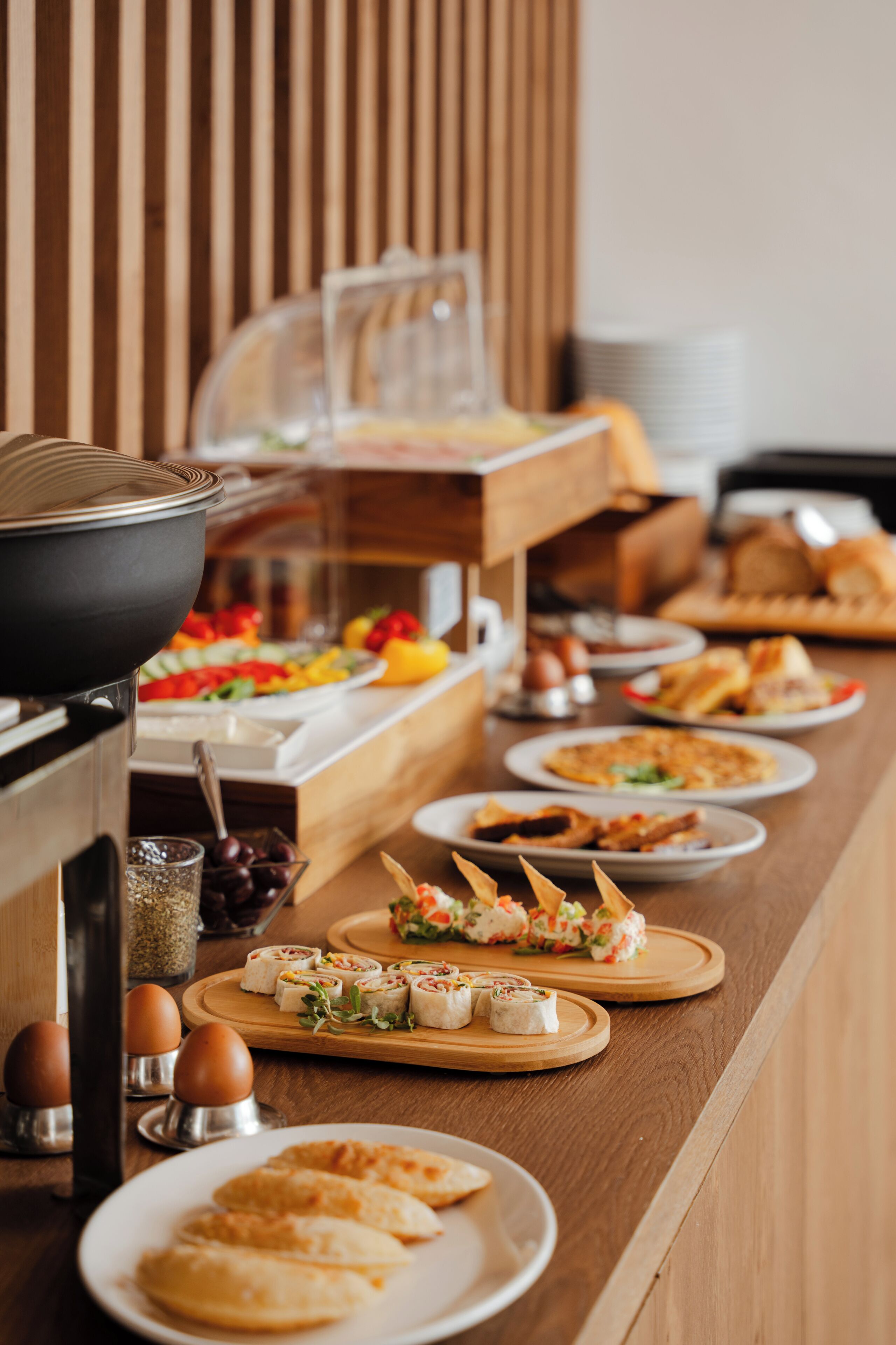 Buffet amb diversos plats, incloent sushi, pastissos i amanides.