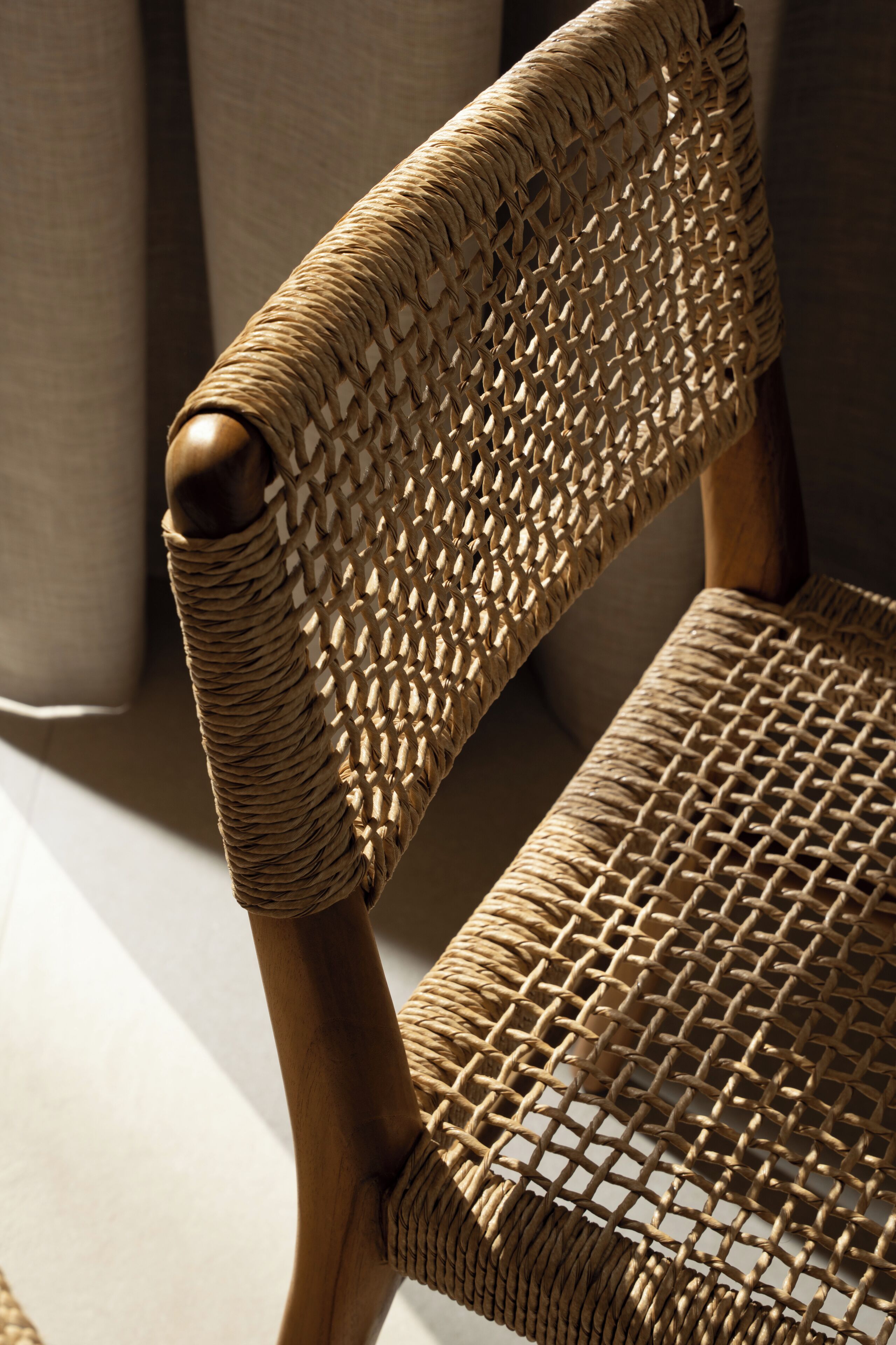 Une chaise en osier, avec un dossier et une assise tissés, fabriquée à partir de fibres naturelles.