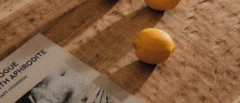 Un livre intitulé « Dogue avec Aphrodite » est posé sur une surface en bois, accompagné de trois citrons.