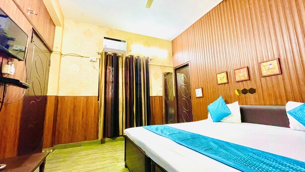 Une chambre d’hôtel équipée d’un lit, d’une armoire, d’un miroir et d’un climatiseur fixé au mur.